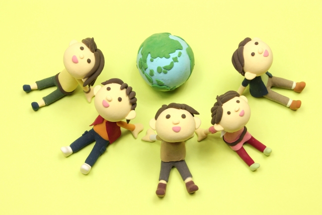 地球の周りに5人の人が見上げて座っている粘土質感の写真です